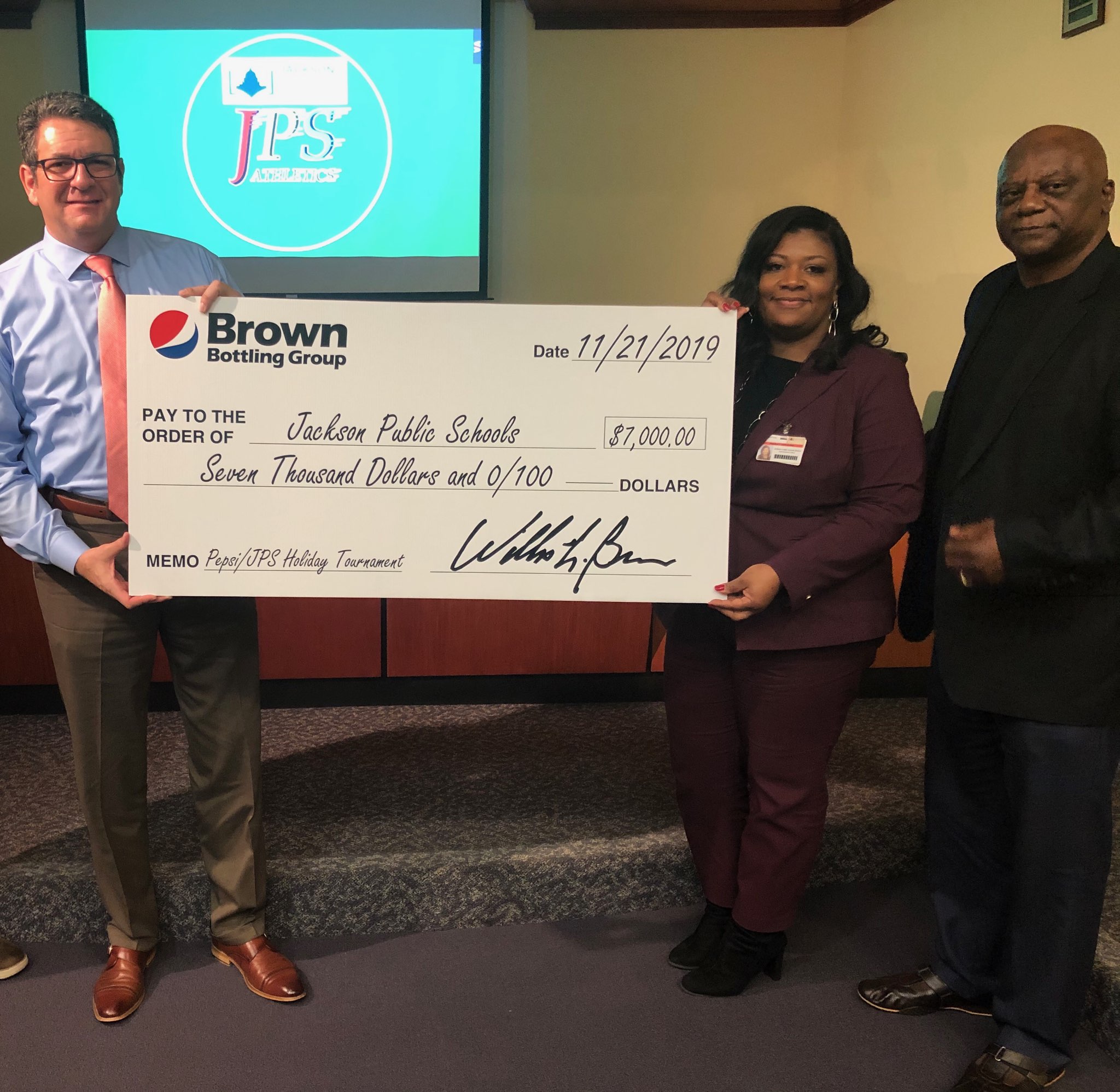 A Brown Bottling representative presents the 2019 sponsorship check for the Pepsi/JPS Holiday Tournament to representatives with Jackson Public Schools. 